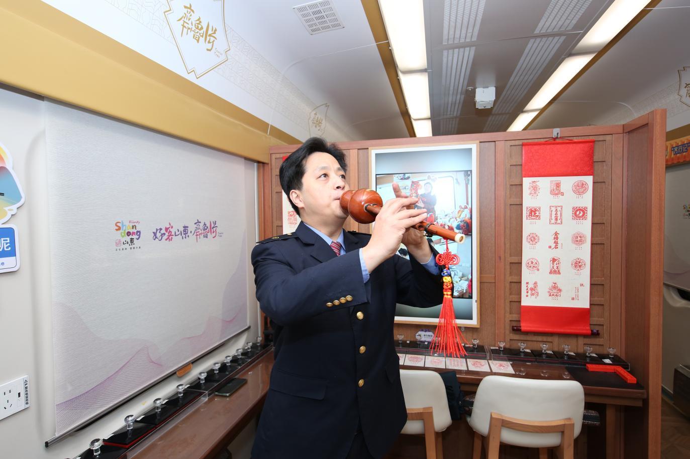 职工张智勇演奏乐器葫芦丝（姜艾勇摄）