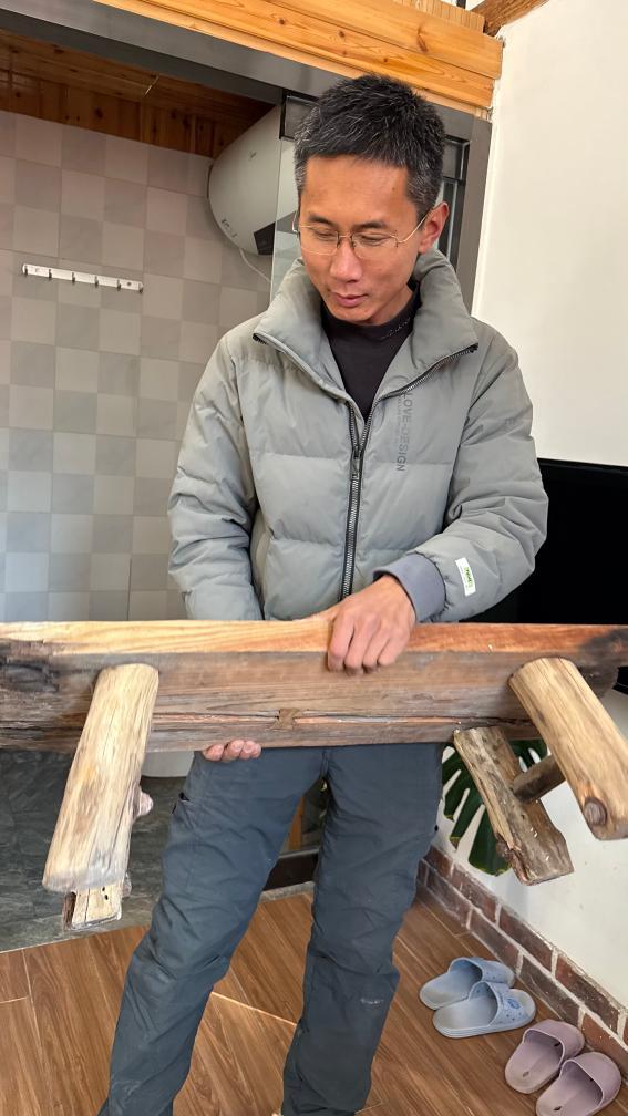 于海洋在其改造的传统海草房民宿中向记者展示其手工制作的家具。新华社记者 李志浩 摄