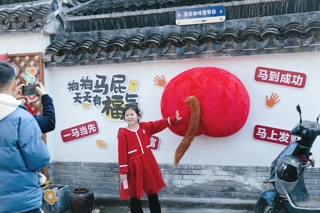 游客在山塘老街与“拍马屁”装饰互动。