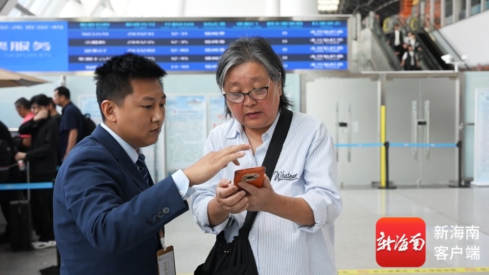 现场工作人员指导旅客线上购票。记者 李厚青 摄