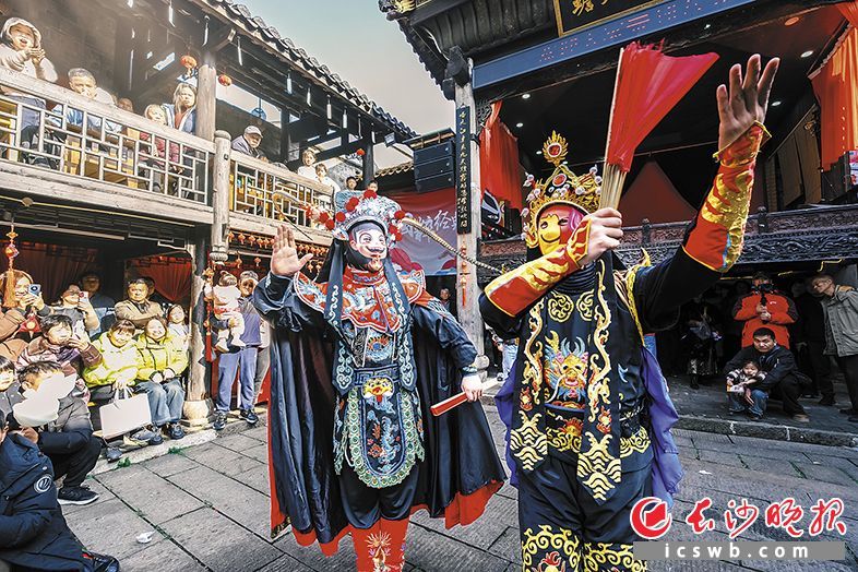 变脸表演中,王启发(左)与师弟亮出“哪吒”和“表情包”等脸谱,获得观众喜爱。