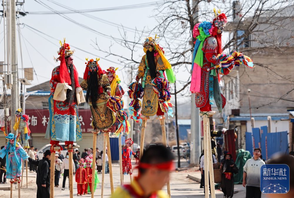 2月21日,在甘肃省静宁县李店镇五方河村,社火队员在表演踩高跷。