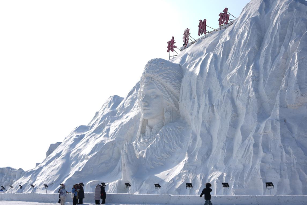 1月14日，长春冰雪新天地内游客观赏“珠穆朗玛”雪雕。新华社记者 颜麟蕴摄
