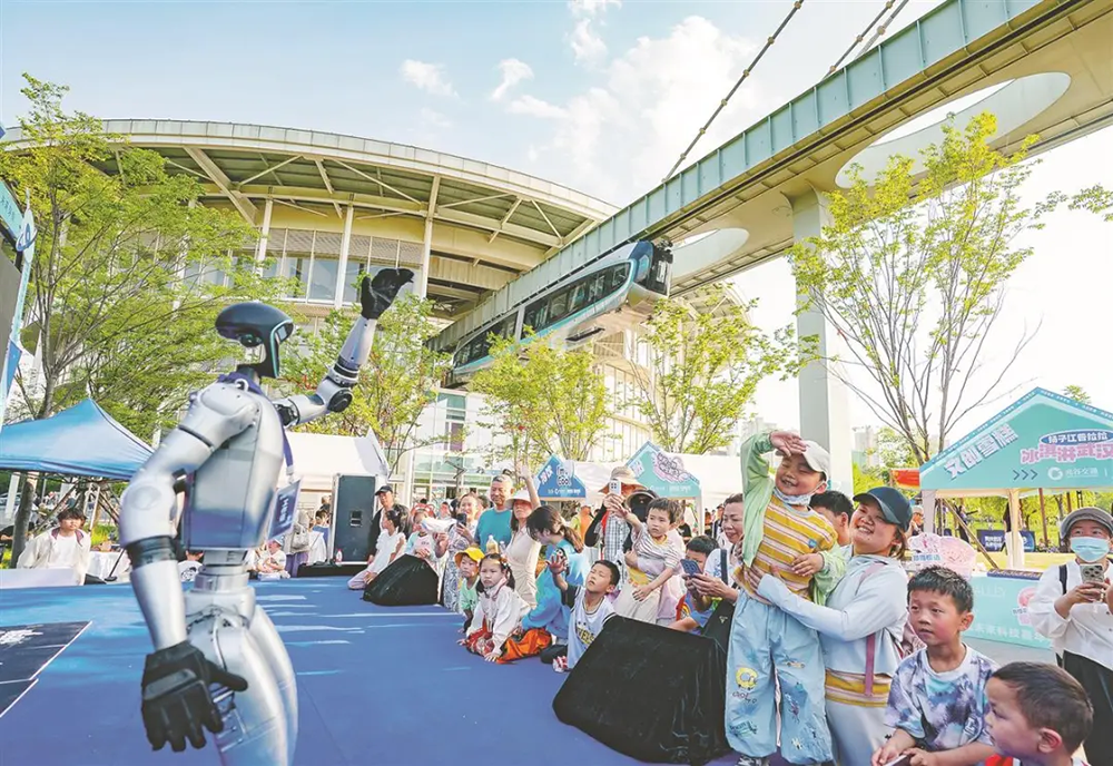 2025年5月1日,在武汉光谷空轨高新大道站,人形机器人与游客互动。湖北日报全媒记者 魏铼 摄