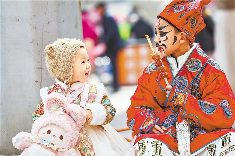 在兰州市七里河区兰州老街社火表演间隙，两位小朋友互动交流。新甘肃&middot;甘肃日报通讯员　侯崇慧