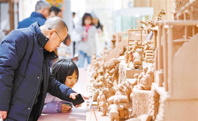 兰州老街活态传承非遗馆内，家长领着孩子欣赏陇原非遗产品。新甘肃&middot;甘肃日报记者　马伊星