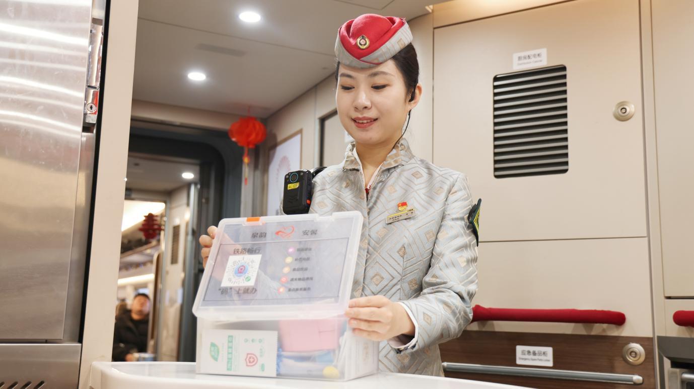 G75次列车长李雪检查应急便民服务箱（陈琳摄）