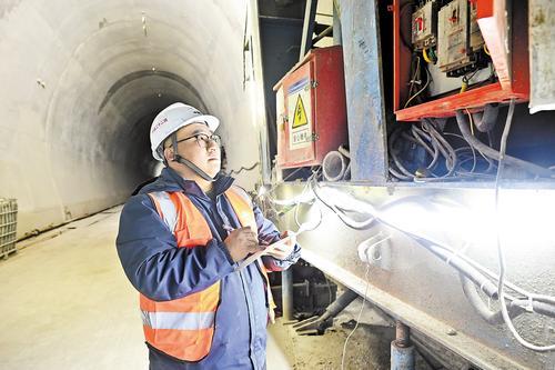 2月24日，太锡铁路荷包隧道建设工地，项目部技术人员杨志华检查二衬液压台车运行情况。本报记者 郭晓通摄