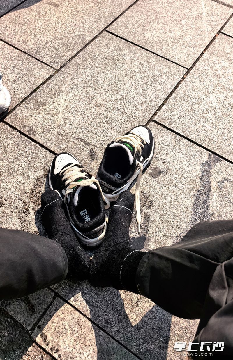 贾先生将小女孩救上岸后来到公园外晒鞋袜。