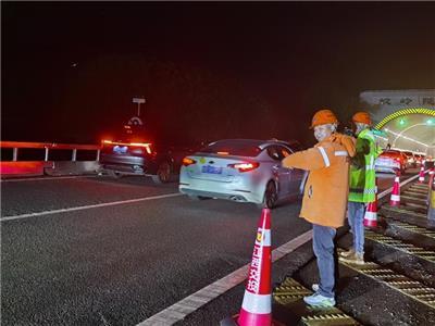 江西交投景德镇管理中心养护人员在杭瑞高速景婺黄段蛟岭隧道口驻点指挥，引导车流有序行进。 （特约通讯员 赵明浩 摄）