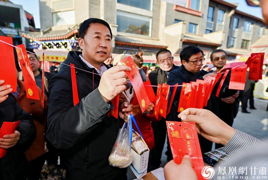 市民在甘肃药业集团展台前猜灯谜