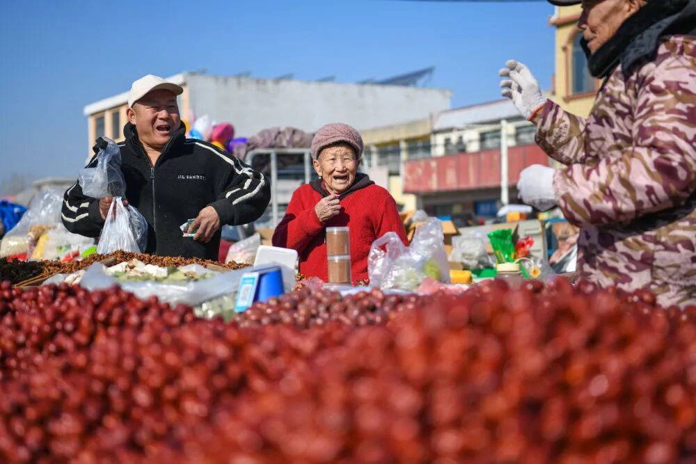 游客在山亭大集上选购干果。新华社发（公哲明 摄）