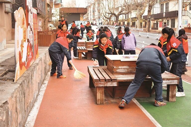 晋城市城区凤台小学雨墨学雷锋志愿服务队的孩子们在社区小游园义务清扫。
