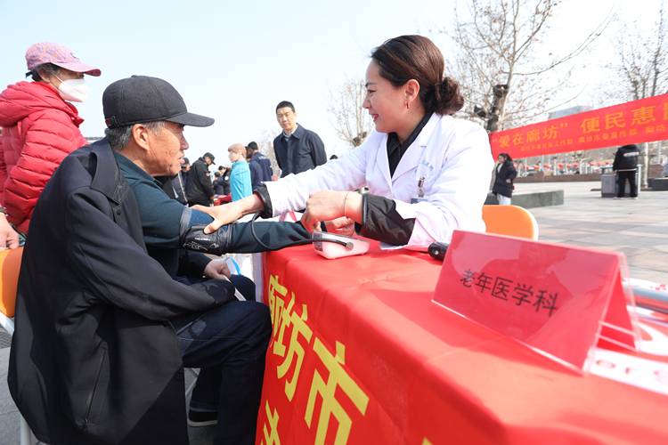 3月3日，在廊坊市区人民公园时代广场，廊坊市人民医院志愿者为老年人提供血压测量服务。董旭旭摄