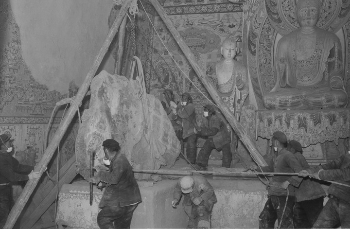 工作人员在莫高窟196窟内处理坠落的窟顶壁画(1957年10月摄) 敦煌研究院供图