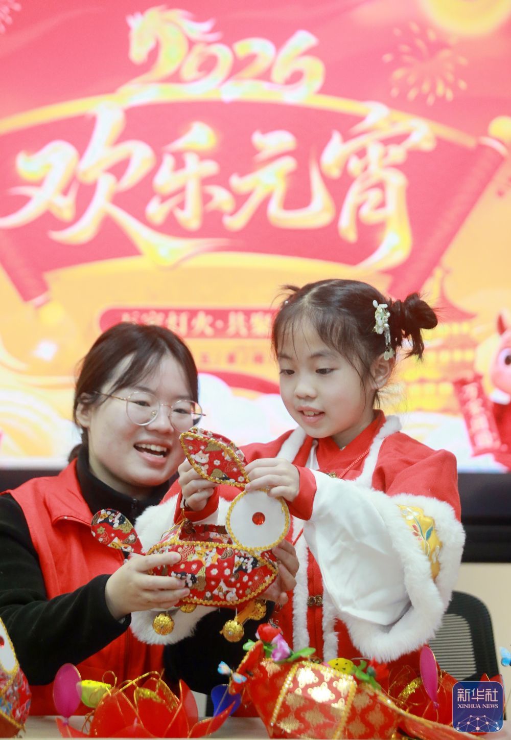 3月2日，在江苏省扬州市徐凝门街社区，志愿者指导小朋友制作花灯。新华社发（孟德龙　摄）