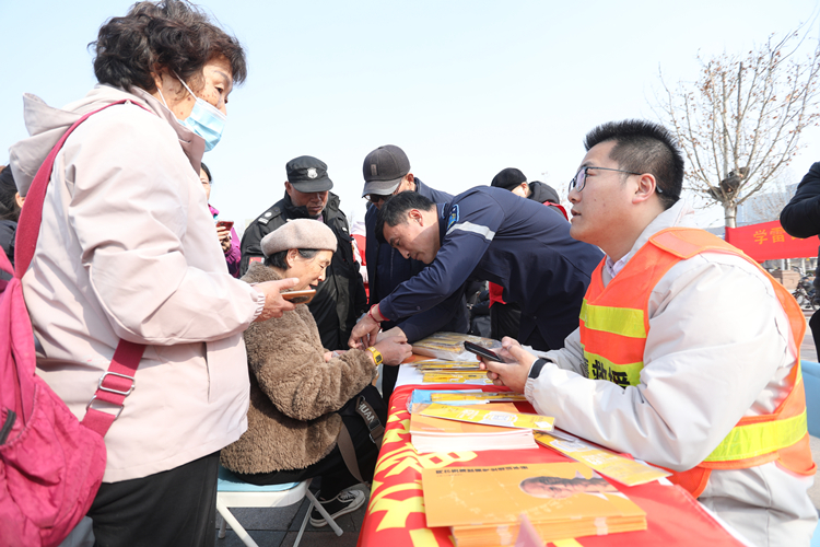 3月3日，在廊坊市区人民公园时代广场，应急救援普及区志愿者为老年人佩戴“黄手环”，守护老人出行安全。董旭旭摄