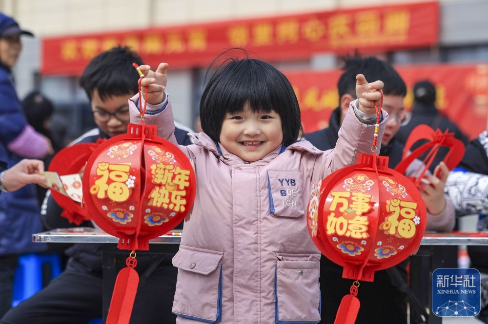 2月28日，小朋友在江苏省泰兴市济川街道商井社区元宵节主题活动中展示灯笼。新华社发（顾继红　摄）