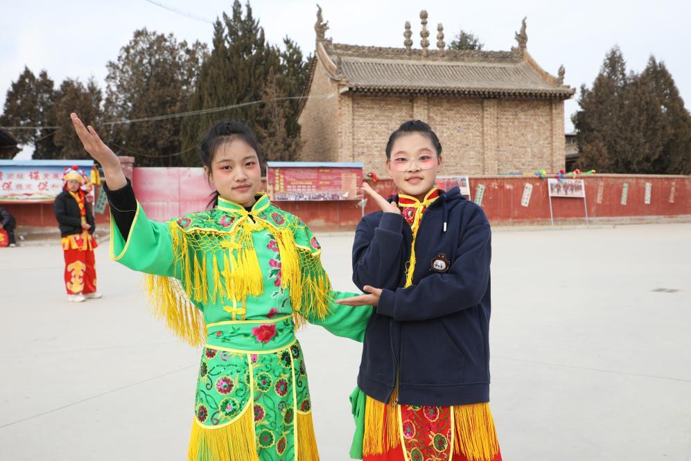 2月14日，在甘肃省兰州市榆中县，王欣怡（右一）、王欣语（右二）在社火表演排练间隙合影。新华社记者　张智敏　摄