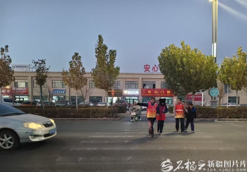 库尔勒市第十小学附近，库尔勒市永安街道康健社区“共享奶奶”志愿服务队帮邻居接孩子。古扎努尔&middot;巴拉提摄