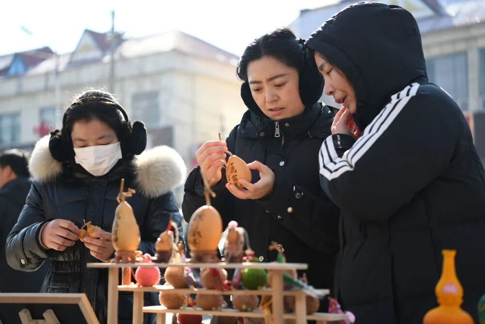 游客在山亭大集上选购葫芦工艺品。新华社发（公哲明 摄）