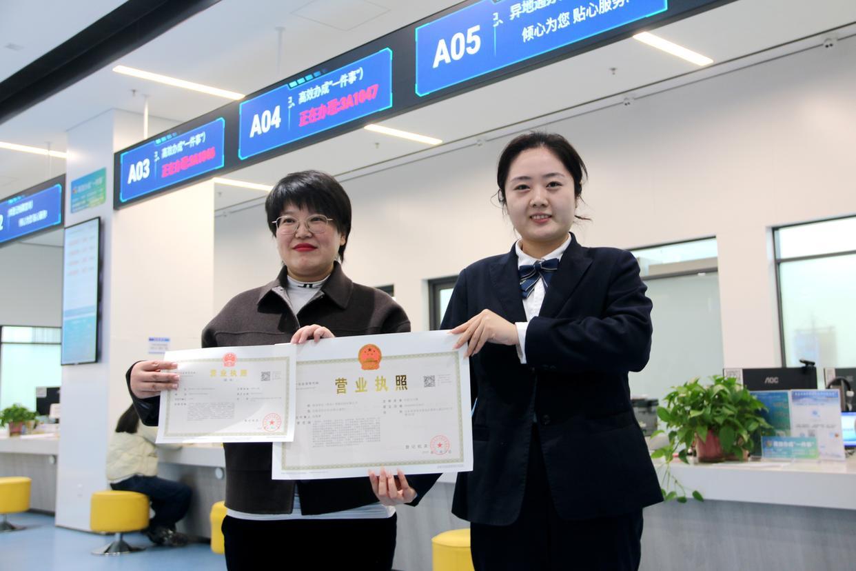 (青岛西海岸新区政务服务中心工作人员为新区首家AI-OPC企业颁发营业执照)