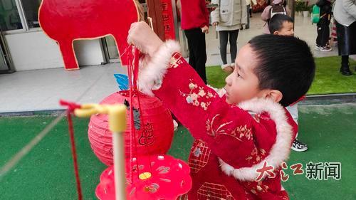 南昌市红谷滩凤凰中心幼儿园的学生在悬挂自己制做的灯笼。