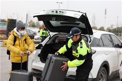景德镇交警帮助旅客拿行李箱。（华佳 摄）