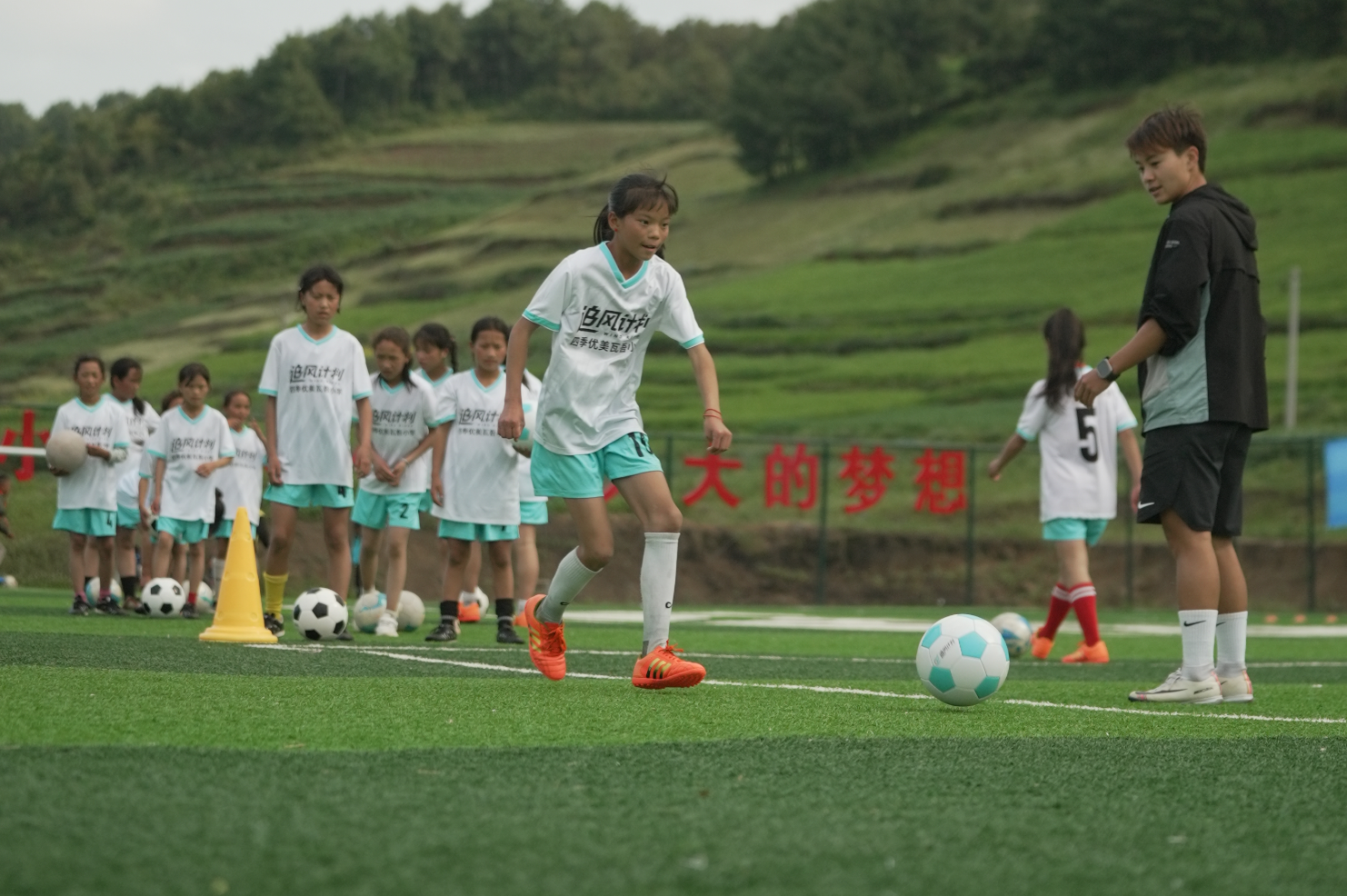 中国女足球员王霜在第二座中国女足主题球场所在的四川昭觉瓦吾小学指导追风女孩