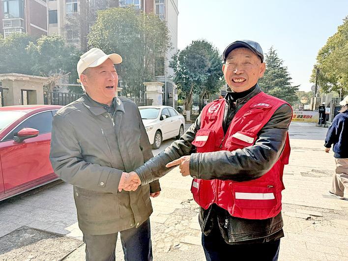 刘天顺(右)和老人在社区里交流