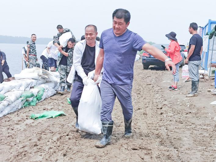 吴劲松（前）防汛抢险中 通讯员供图