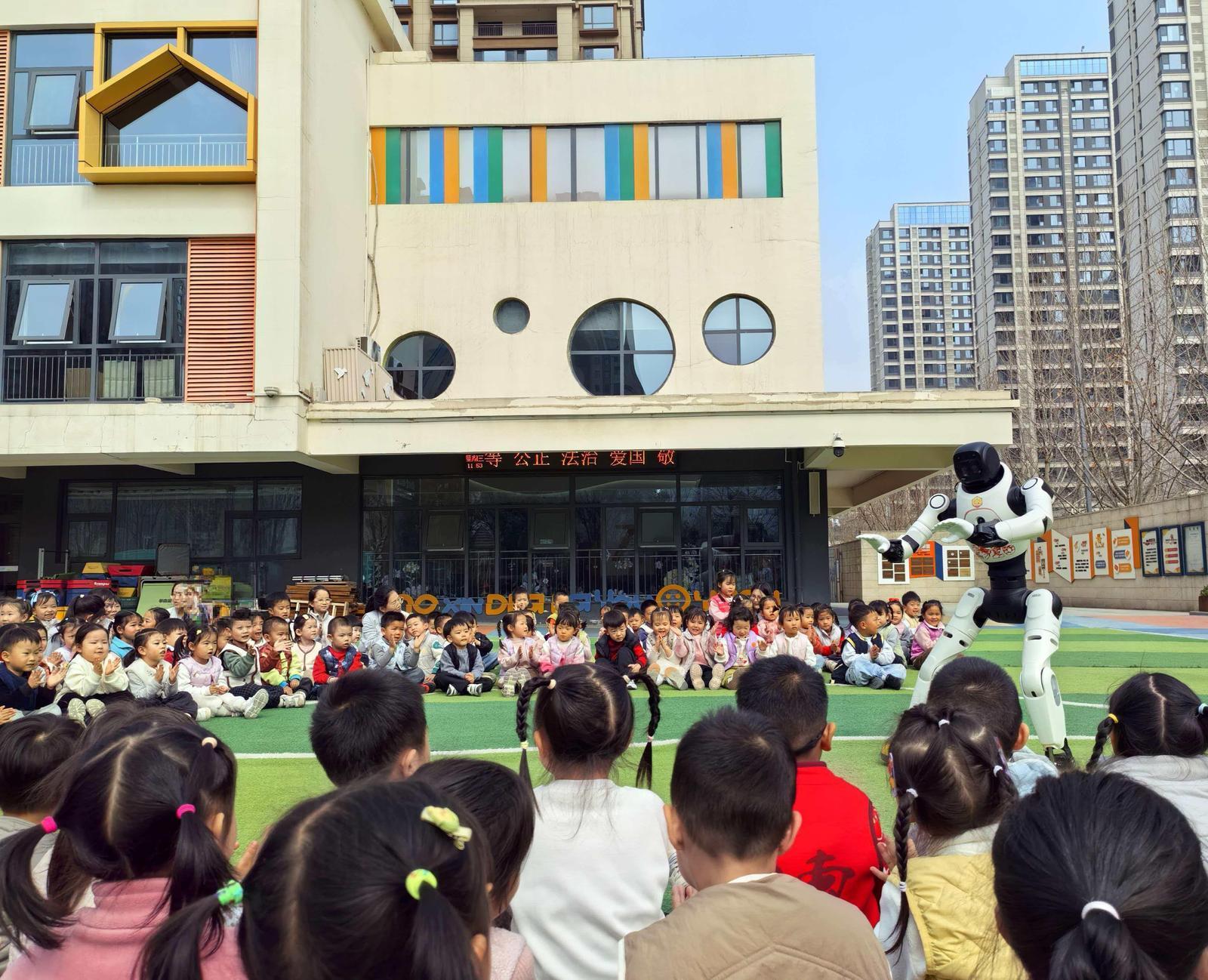 户外运动时间，机器人“莱宝”与小朋友们互动（首席记者 程静 摄）