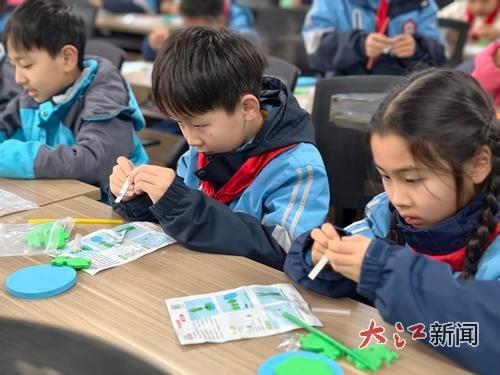 南昌市豫章学校教育集团光明校区的学生在课堂上制作手工作品。