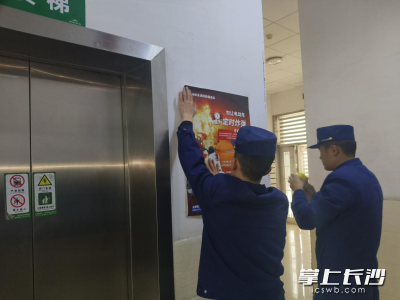 消防宣传员正在张贴安全海报。 长沙晚报通讯员 宁倩 摄