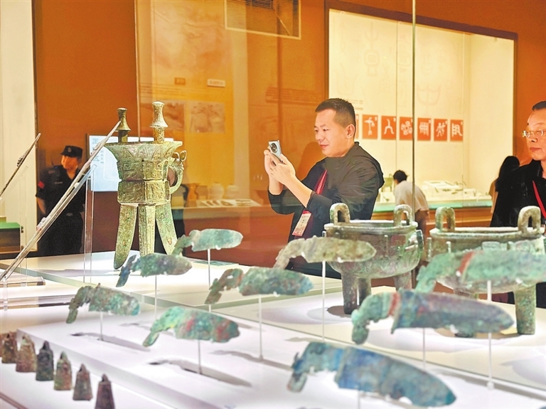 在殷墟博物馆“伟大的商文明”展厅内，游客正在拍摄展陈的青铜器。河南日报全媒体记者 赵阿娜 摄