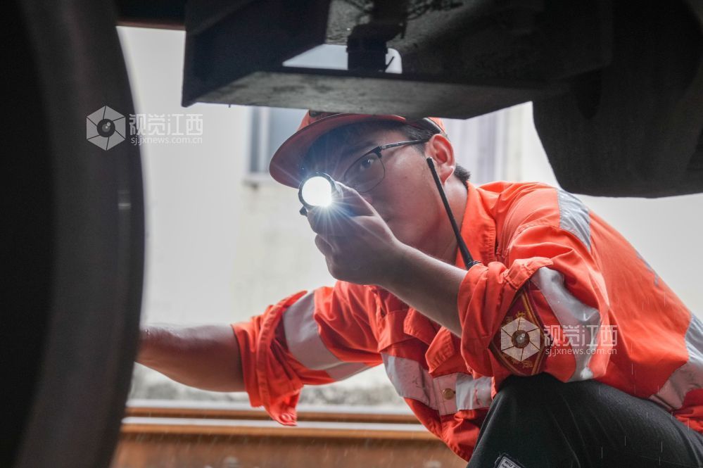 赣州东运用车间检车员在检查钩缓装置。