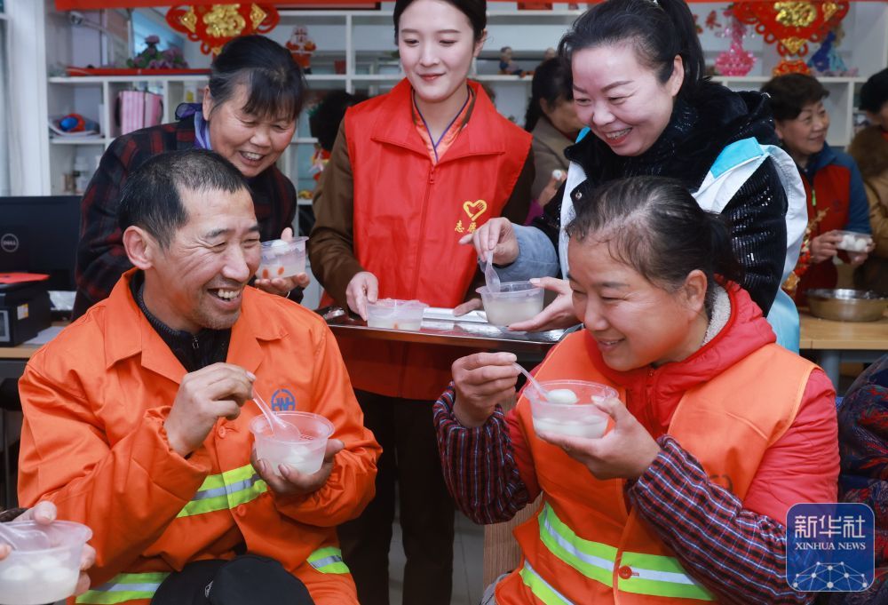 2月27日，在武汉市武昌区黄鹤楼街道读书社区，环卫工人品尝元宵。新华社发（赵军　摄）