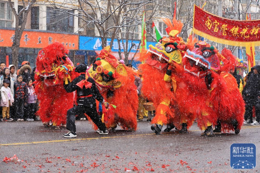3月1日，社火队员在甘肃省定西市安定区内官营镇先锋村冒雪表演舞狮。新华社发（陈永刚　摄）