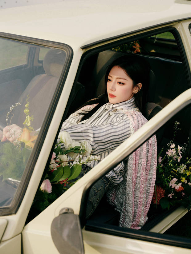 迪丽热巴车内满是鲜花，眼神沉静，松弛文艺。