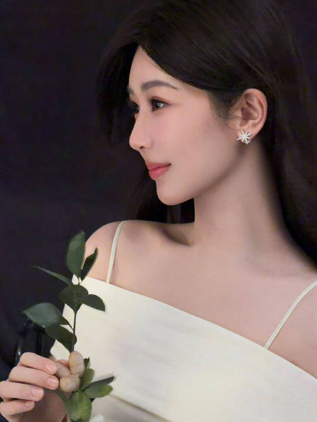 杨紫手持绿植，吊带白裙温柔又清新。