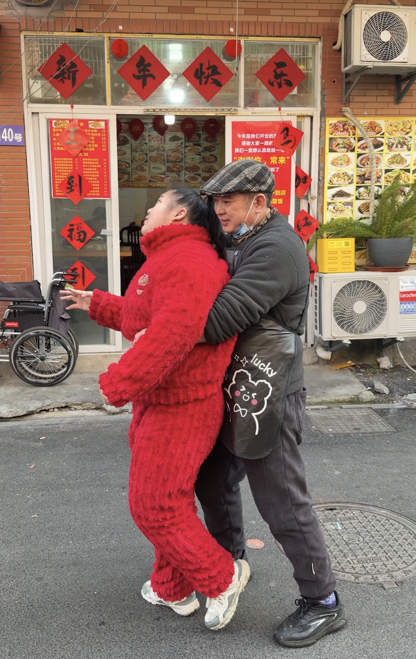 （从女儿五六岁起，彭大哥每天抱着女儿做康复训练，这一抱就是近20年）