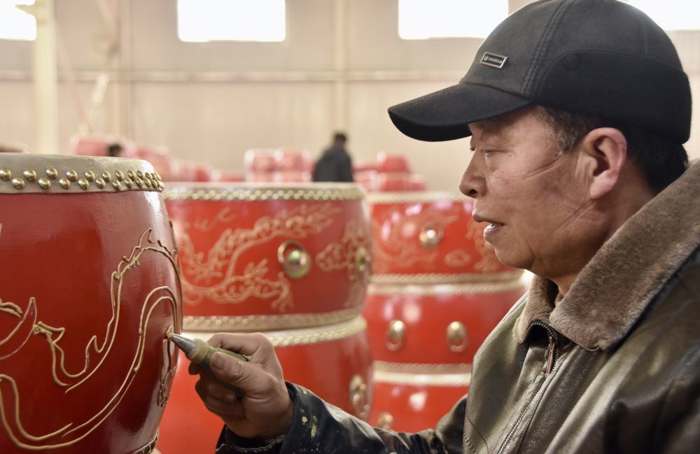 刘从社正在鼓身上勾画出造型。新华社记者 郑昕 摄
