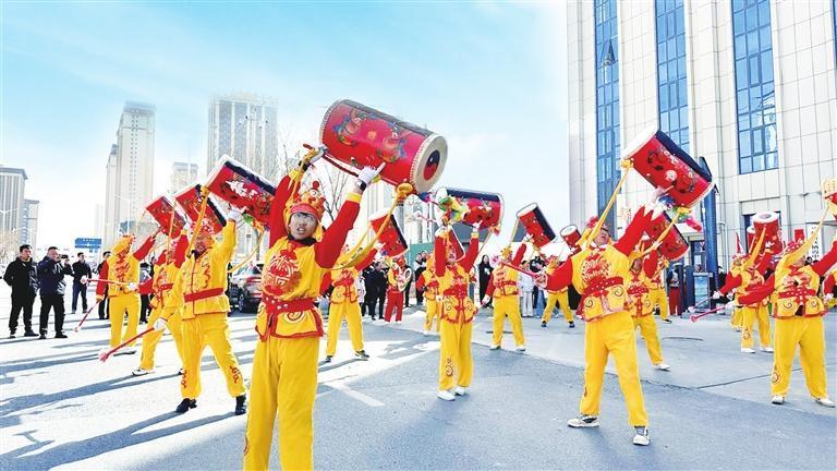 春节期间，栖霞中心社区组织开展以“传承民俗文脉　喜迎马年新春”为主题的民俗社火表演活动。图为太平鼓队的激情表演，引得居民掌声不断。兰州新区报记者　姜波　摄