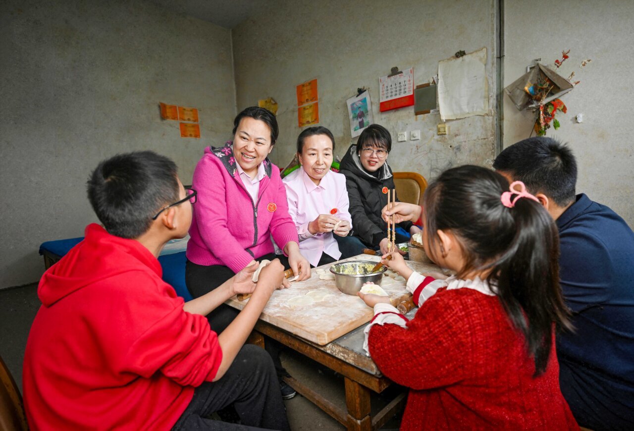 3月1日，衡水市“爱心妈妈”刘艳梅（左二）、居春萍（左三）、彭娜（左四）来到孩子们家中一起包饺子。河北日报记者 张昊摄