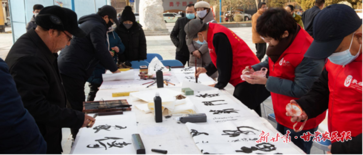 2025.12.04日，敦煌市举办的“敦煌有礼”国际志愿者日文明实践宣传活动中，书法志愿者为群众书写家风内容的书法作品