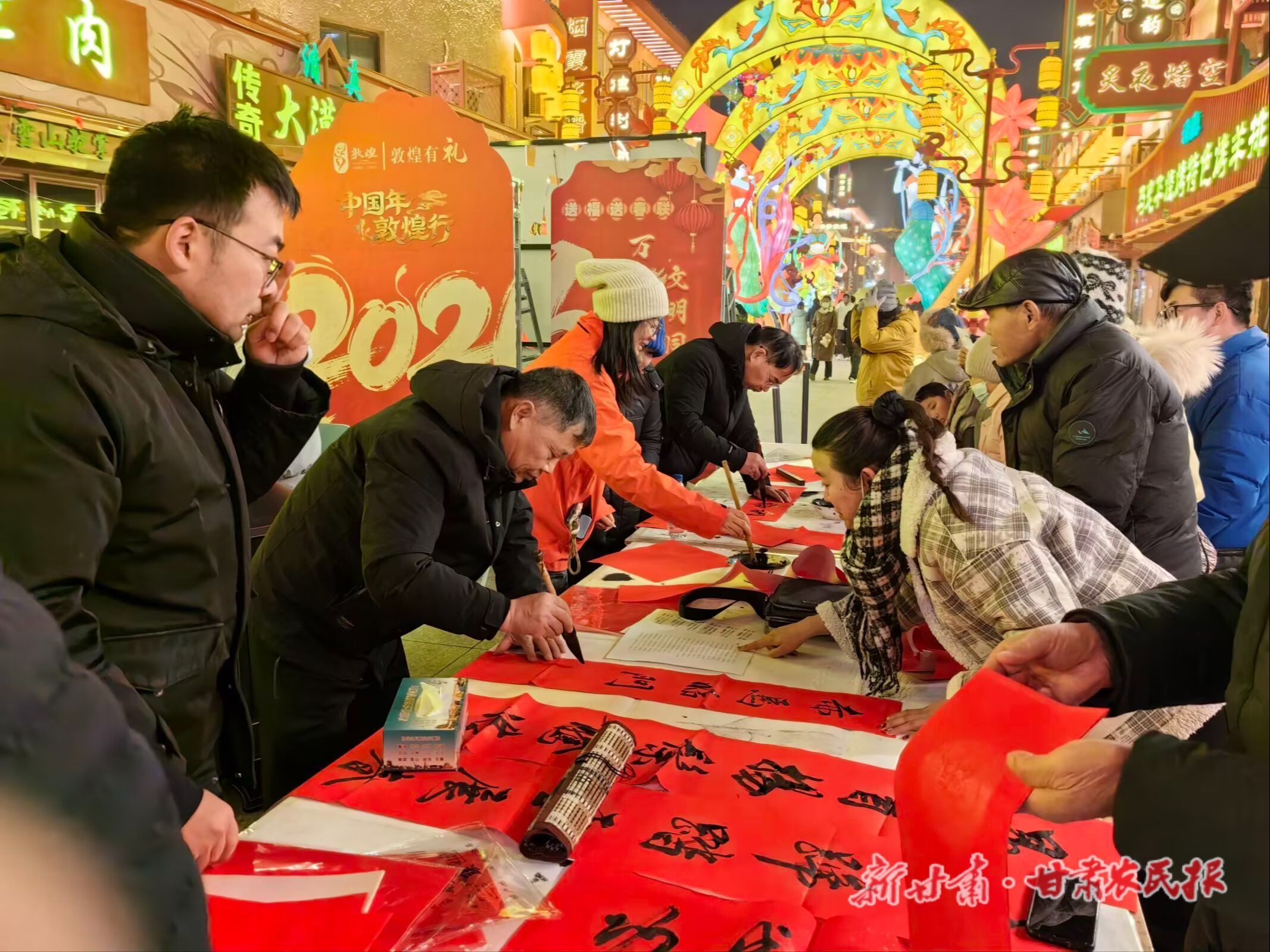 2026年2月，敦煌市“万福迎春&middot;文明同行”送福送春联活动中，志愿者正在为群众书写春联