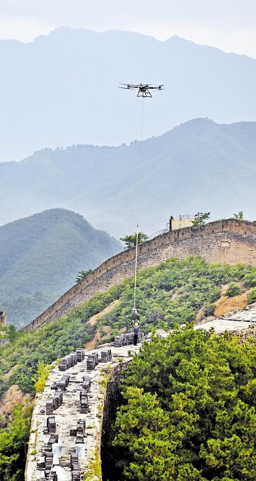 2025年8月18日，金山岭长城修缮工程施工现场，无人机在吊运青砖。 本报记者 贾恒摄