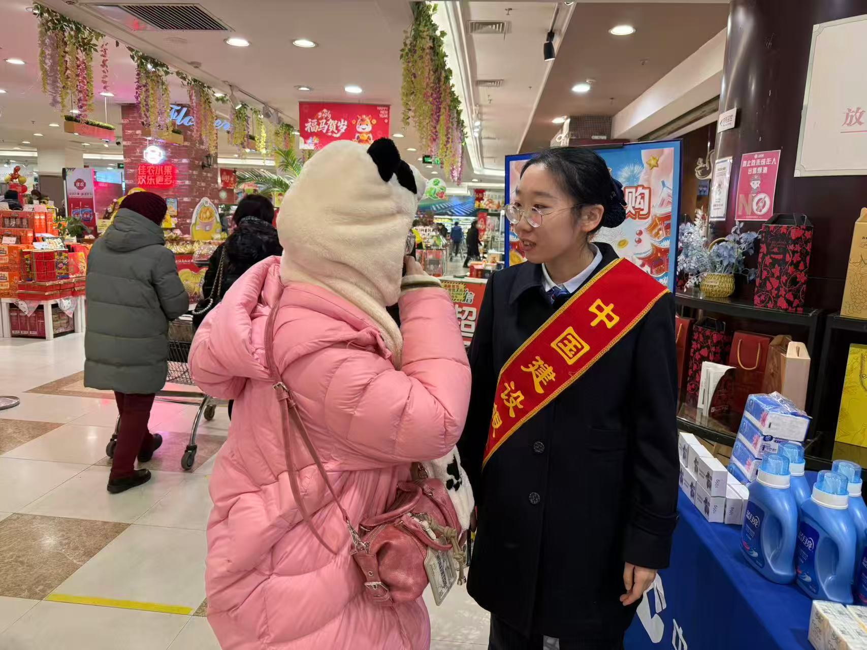 （建设银行哈尔滨新阳支行“张富清金融服务队”队员向参与活动的市民讲解相关政策）