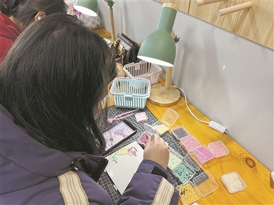 女孩聚精会神做拼豆手工