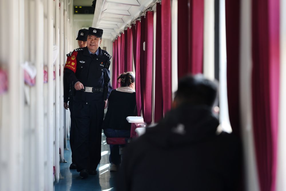 3月11日，兰州铁路公安处乘警支队民警段文革（前）在兰州开往上海的T118次列车上巡查。新华社记者　陈斌　摄